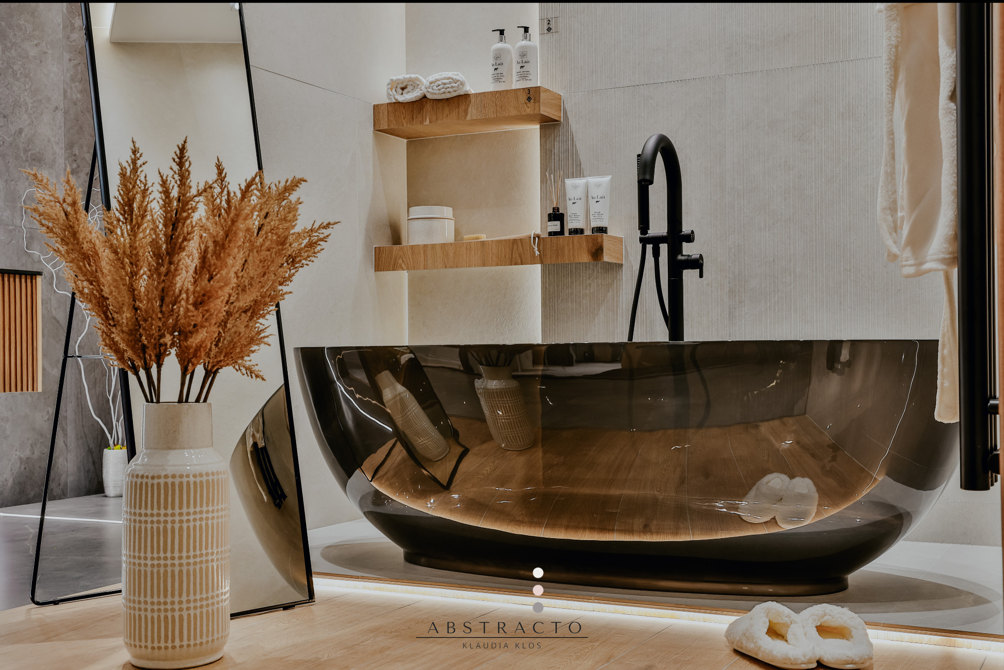 Nowoczesna łazienka z czarną, transparentną wanną, drewnianymi półkami i pampasową trawą w ozdobnym wazonie. Minimalistyczny design.