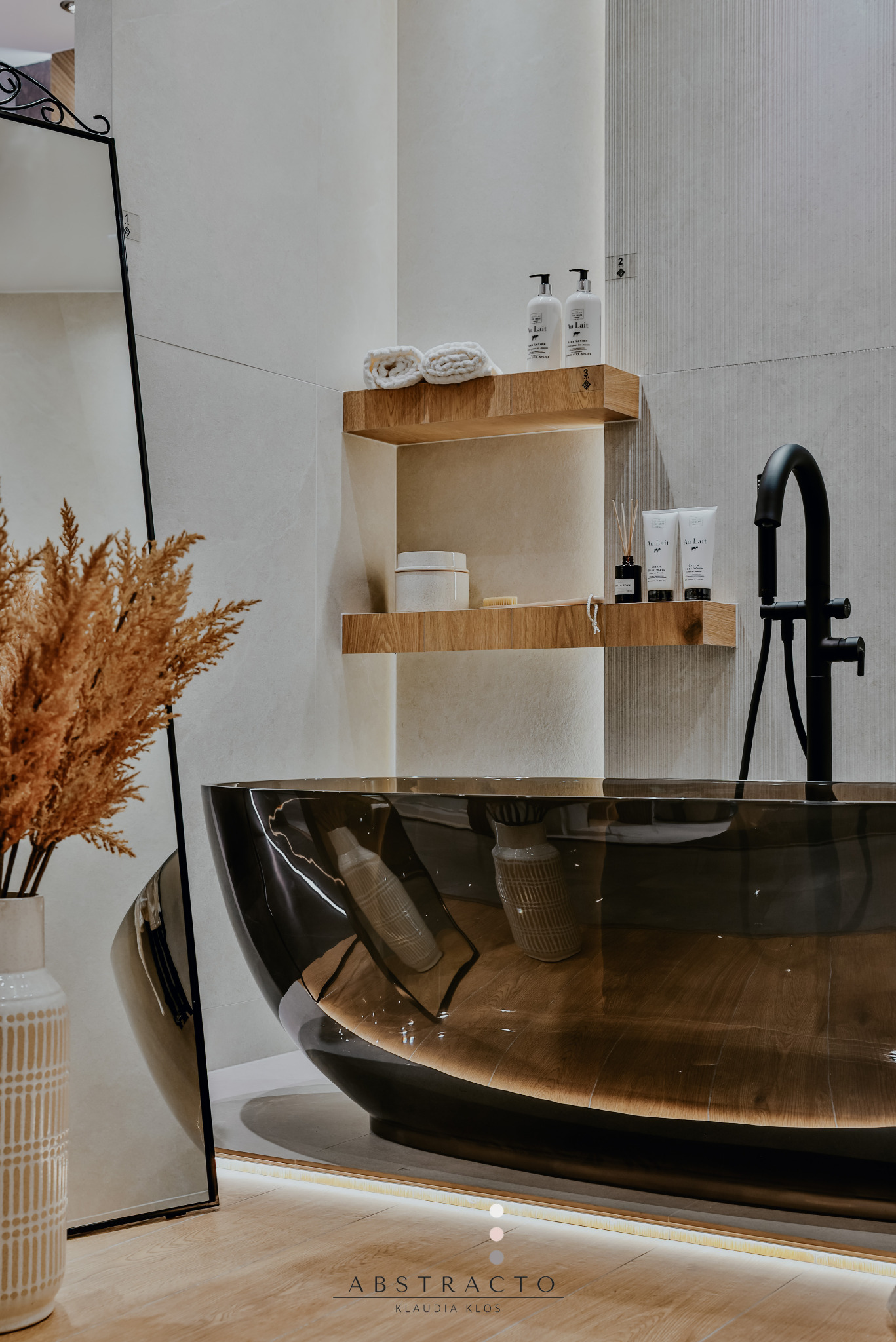 Elegancka łazienka z wanną z ciemnego szkła, drewnianymi półkami i czarną armaturą. Minimalistyczny design, oświetlenie LED. Nowoczesne akcesoria łazienkowe.