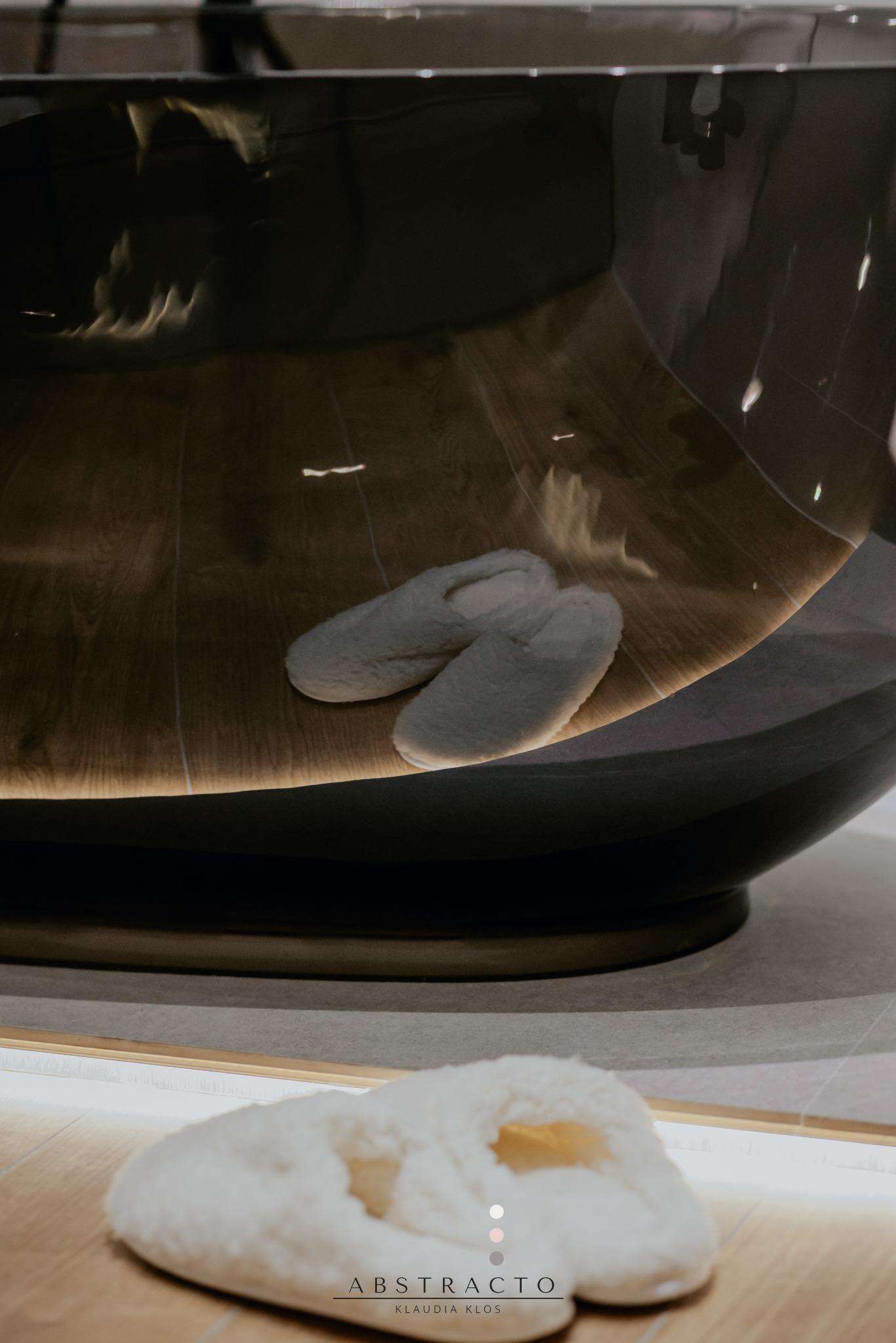 Nowoczesna łazienka z wolnostojącą wanną i miękkimi kapciami. Oświetlenie LED podkreśla luksusowy charakter wnętrza.