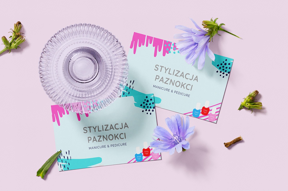 Dwie wizytówki z napisem 'Stylizacja Paznokci Manicure & Pedicure' w pastelowych kolorach, ozdobione kwiatami i szklanym naczyniem na jasnoróżowym tle.