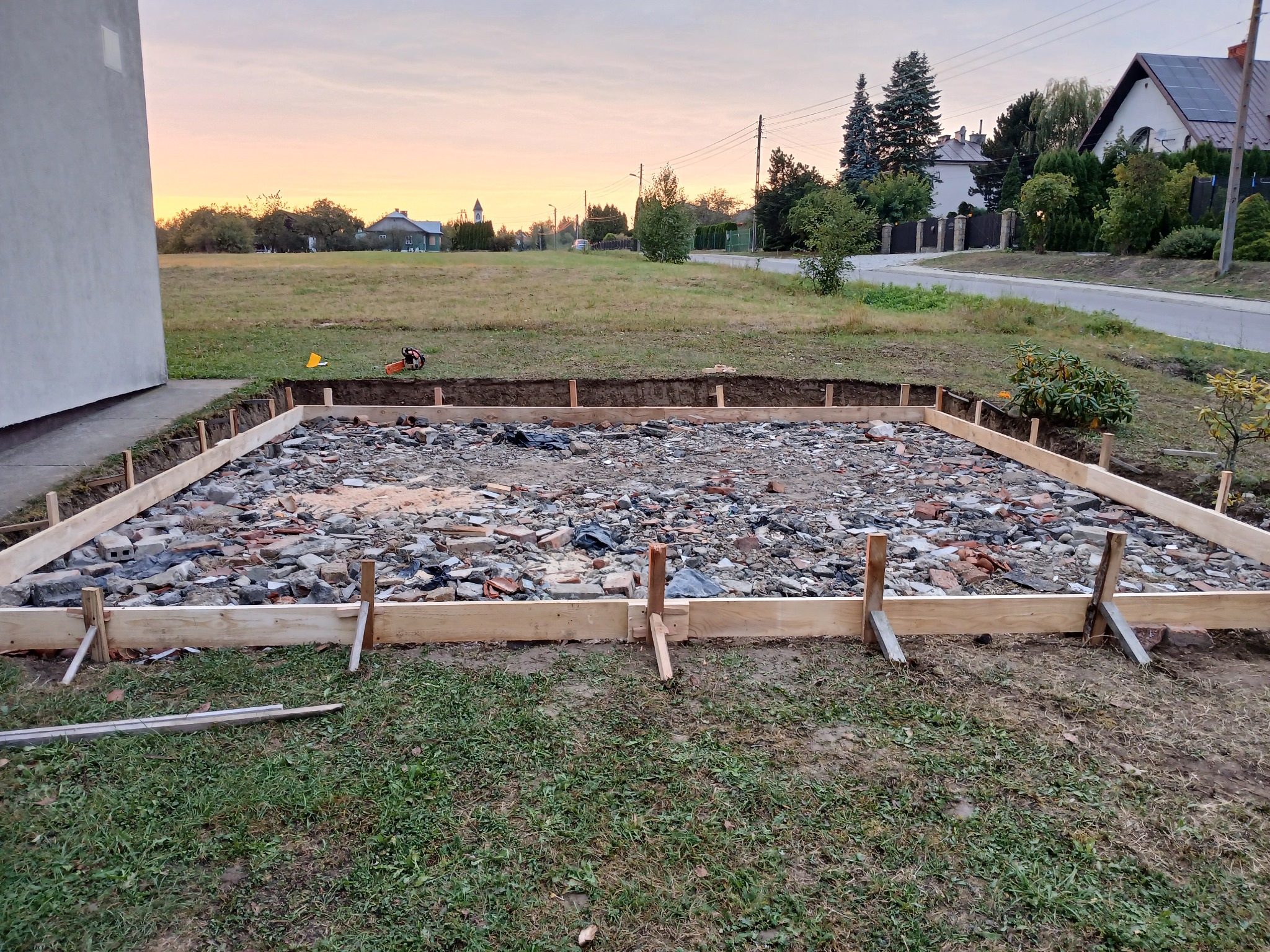 Szczegółowy widok szalunku fundamentów w Bieczu, przygotowanego na gruzowisku. W tle widoczny krajobraz z elementami zabudowy i zieleni.