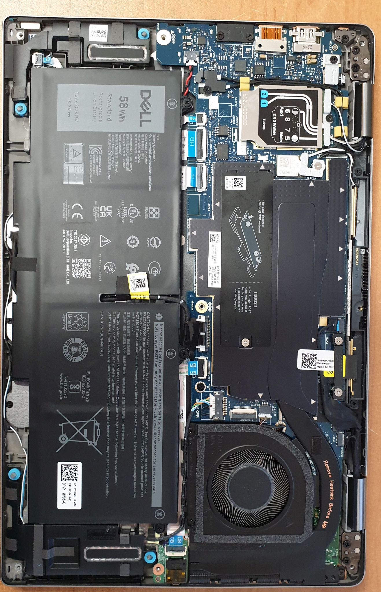 Wnętrze laptopa Dell po demontażu obudowy, widoczna bateria, płyta główna, wentylator i inne komponenty. Przegląd serwisowy komputera w Raciborzu.