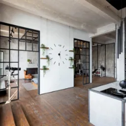 Nowoczesne wnętrze z dużymi, przeszklonymi drzwiami z czarnymi ramami, drewnianą podłogą, białymi ścianami z minimalistycznym zegarem i elementami dekoracyjnymi w postaci roślin.