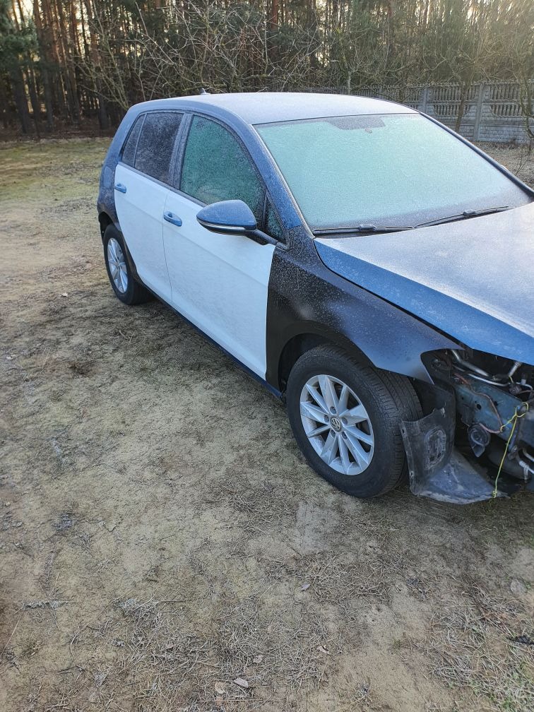 Uszkodzony samochód osobowy po kolizji, z elementami karoserii w kolorze białym i czarnym, pokryty szronem, widoczne uszkodzenia w przedniej części pojazdu.