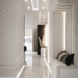Nowoczesny korytarz z marmurową podłogą, oświetleniem LED wzdłuż ścian i sufitu, oraz wnęką z tapicerowanym siedziskiem i dekoracyjnymi poduszkami. W tle widoczny salon z zasłonami i widok...