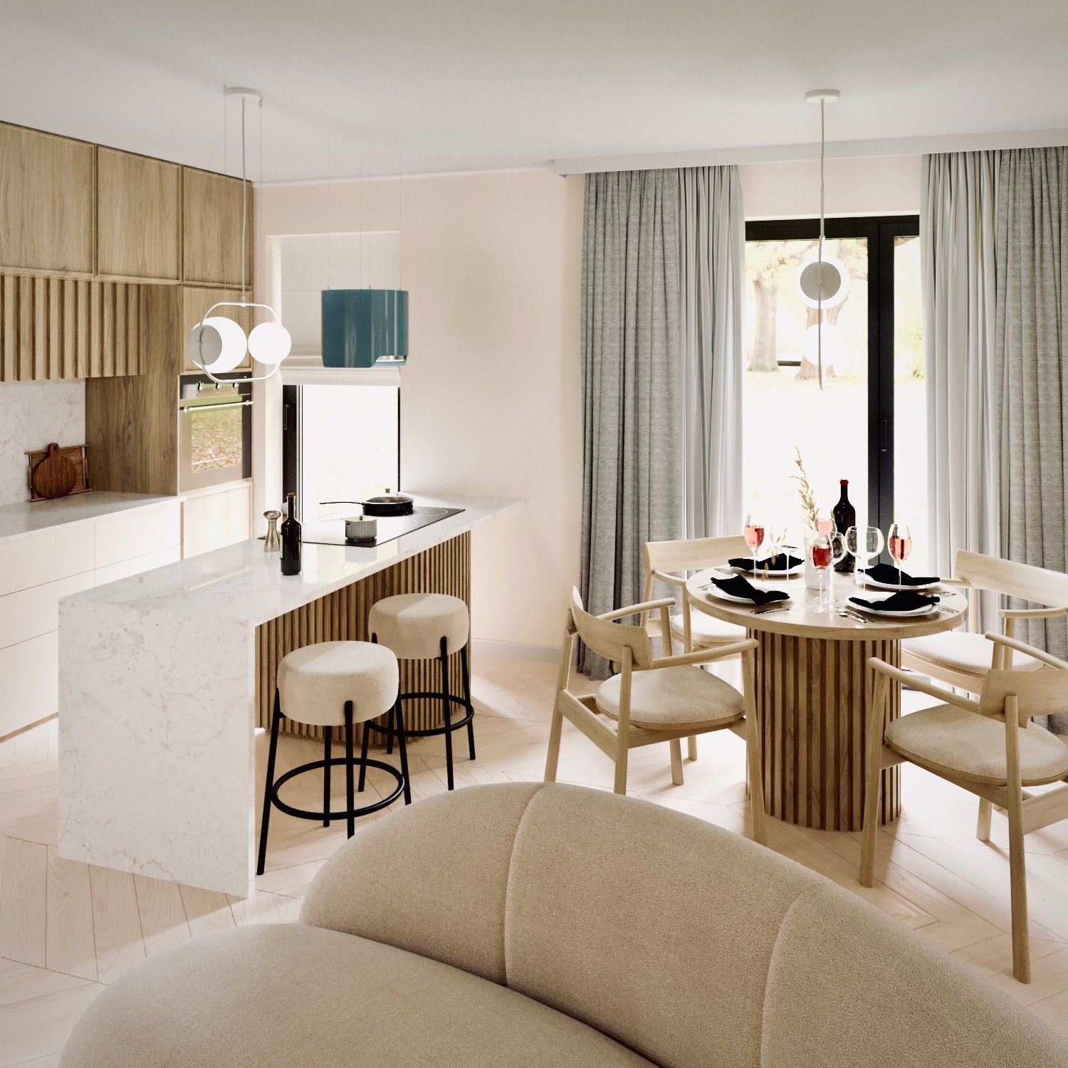 Jasne wnętrze: kuchnia z marmurowym blatem, hokerami i drewnianymi szafkami przechodzi w jadalnię z okrągłym stołem i krzesłami, całość doświetlona nowoczesnymi lampami wiszącymi.