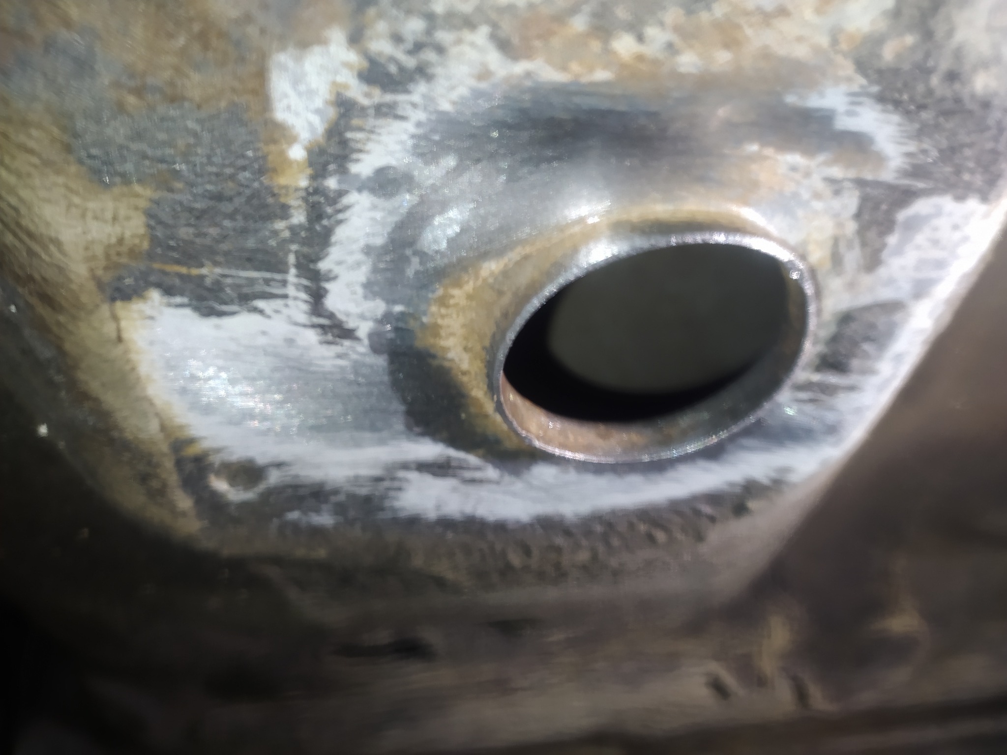 Zbliżenie na fragment podwozia pojazdu w Żabnie po piaskowaniu, widoczny otwór i ślady obróbki.