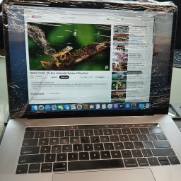Fix Lab Center sp. z o.o. - Laptop MacBook Pro z włączonym YouTube, ekran zabezpieczony folią. Widoczny film National Geographic o cudach natury. Klawiatura w tle.