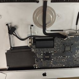 Fix Lab Center sp. z o.o. - Wnętrze naprawianego komputera iMac, widoczna płyta główna, radiator i inne komponenty. Sprzęt po demontażu, w trakcie serwisu.