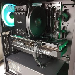 Fix Lab Center sp. z o.o. - Wnętrze komputera stacjonarnego z kartą graficzną MSI GeForce RTX, chłodzeniem Be Quiet i pamięcią RAM Fury, podświetlone na zielono i niebiesko.