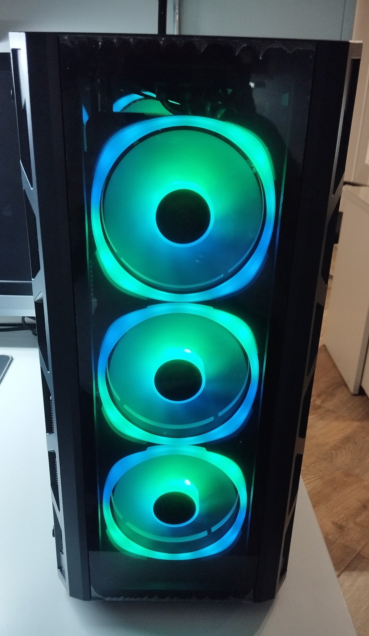 Czarna obudowa komputera stacjonarnego z trzema podświetlanymi na niebiesko-zielono wentylatorami, widoczna we Wrocławiu.