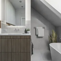 Jasna łazienka na poddaszu z wanną wolnostojącą, drewnianą szafką pod umywalką i akcentami z płytek imitujących drewno na ścianie. Minimalistyczne baterie umywalkowe i dodatki.