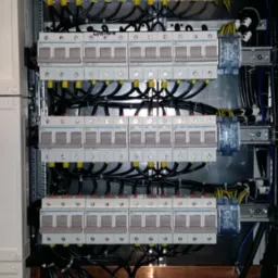 Rozdzielnia elektryczna z bezpiecznikami i okablowaniem w Radomyślu nad Sanem, widok z bliska ukazujący precyzyjne połączenia i uporządkowane ułożenie przewodów.