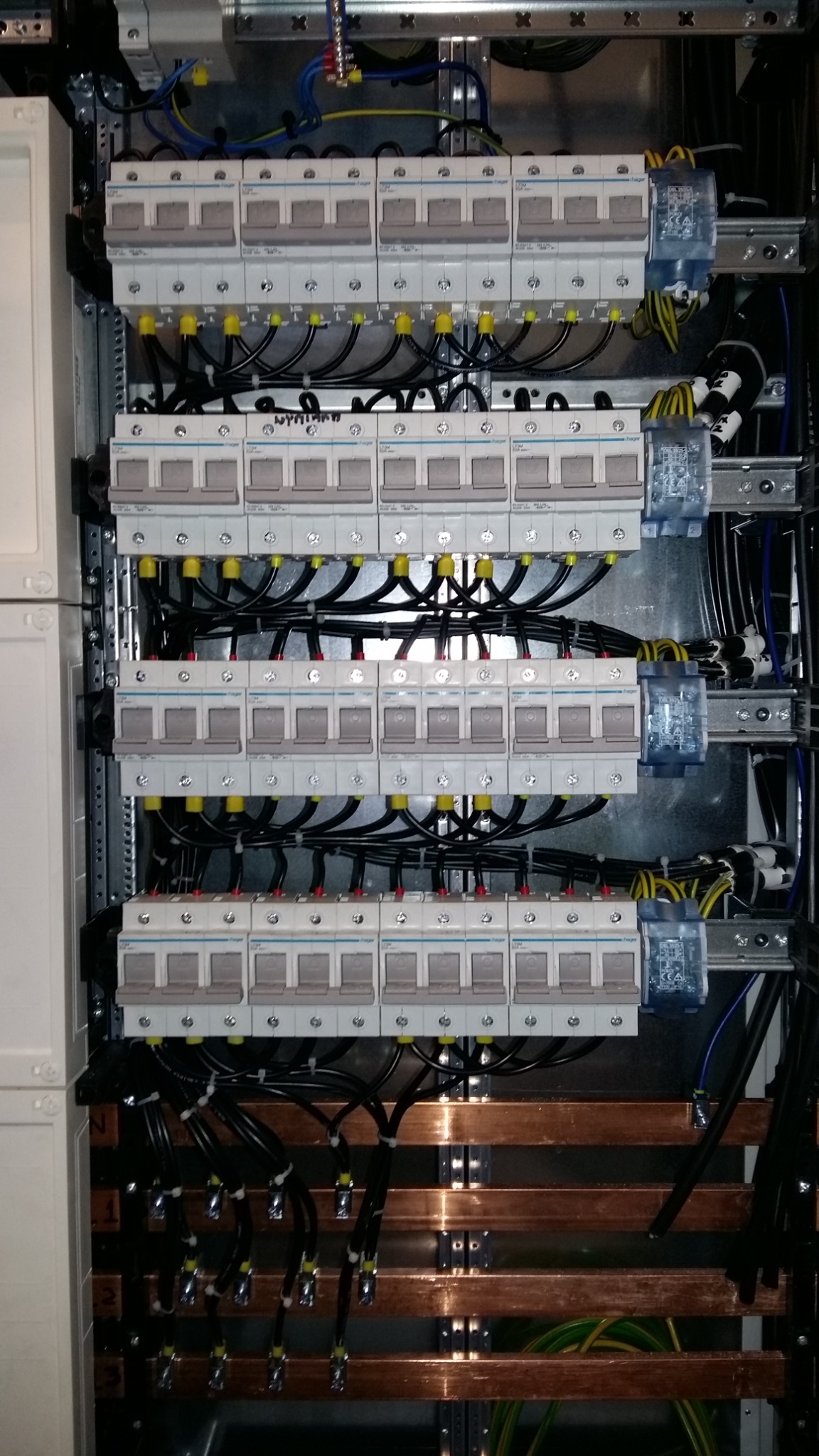 Rozdzielnia elektryczna z bezpiecznikami i okablowaniem w Radomyślu nad Sanem, widok z bliska ukazujący precyzyjne połączenia i uporządkowane ułożenie przewodów.