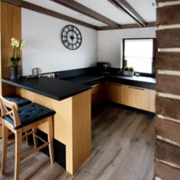 Jasna kuchnia z drewnianymi szafkami, czarnym blatem, dwoma hokerami z czarnymi siedziskami, zegarem na ścianie i ceglanym wykończeniem ściany po prawej stronie.