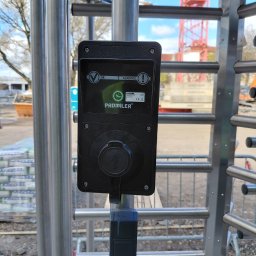 Luneco Sp. z o.o. - Zamontowany alkomat przy bramce obrotowej na budowie. Urządzenie marki Promiler z wyświetlaczem i pokrętłem. W tle widoczny żuraw budowlany i teren budowy.