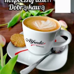Filiżanka kawy Alfredo Espresso z pianką w kształcie serca, ciasteczko na białym spodku, srebrna łyżeczka, tulipan i napis 'Rozpocznij dzień Dobrą kawą'.