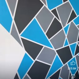 ZTM - Ściana pomalowana w geometryczne wzory z użyciem farb w odcieniach błękitu, szarości i czerni, oddzielone białymi liniami.