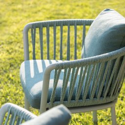 Tarcon Tarasy - Dwa nowoczesne krzesła ogrodowe z jasnoszarą ramą i siedziskiem z poduszką w odcieniach zieleni, oplecione sznurkiem, ustawione na trawniku w słoneczny dzień.