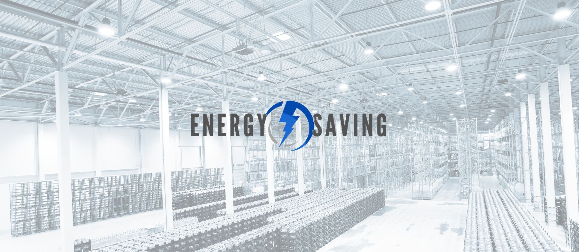 Wnętrze hali magazynowej z regałami i oświetleniem, nałożony napis 'Energy Saving' z symbolem błyskawicy w niebieskim okręgu, sugerujący oszczędność energii w dużych obiektach przemysłowych.