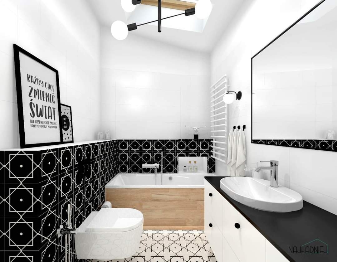 Biało-czarna łazienka z geometrycznym wzorem na płytkach, drewnianą obudową wanny i wiszącymi plakatami z napisami.
