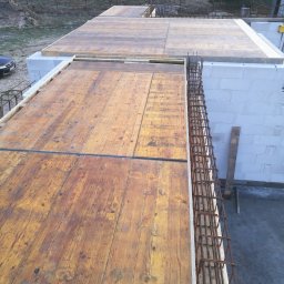 Dom na miarę - Wylany strop z drewnianym szalunkiem i zbrojeniem na ścianach z betonu komórkowego, widok z góry na budowę domu jednorodzinnego.