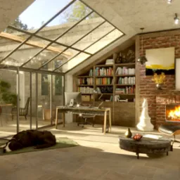 Jasne, przestronne wnętrze poddasza z przeszklonym dachem, ceglaną ścianą z kominkiem, biurkiem z komputerem, regałem z książkami i śpiącym psem na dywanie.