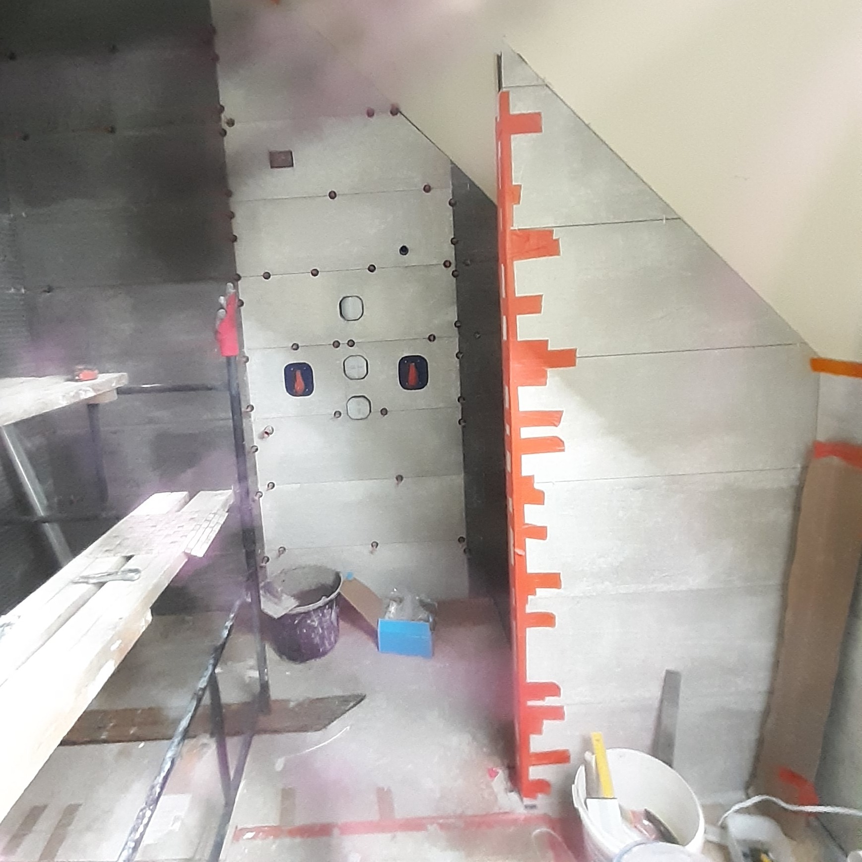 Montaż płyt karton gips w łazience na poddaszu ze skośnym sufitem, widoczne profile i narzędzia glazurnicze.