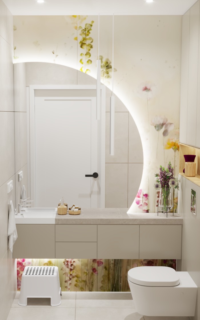 Nowoczesna łazienka z podświetlanym lustrem w kształcie półksiężyca, kwiatowym motywem na ścianie i beżową szafką pod umywalką z podświetleniem LED. Widoczny biały taboret i wisząca toaleta.
