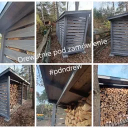 Szara, drewniana wiata na drewno opałowe z poziomymi szczeblami, wypełniona pociętymi kawałkami drewna, na tle leśnego krajobrazu.