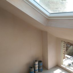 RAFFENER Rafał Jasiukajć - Poddasze po szpachlowaniu ścian i sufitu z oknem dachowym, widoczne rolki ołowiu pod ścianą.