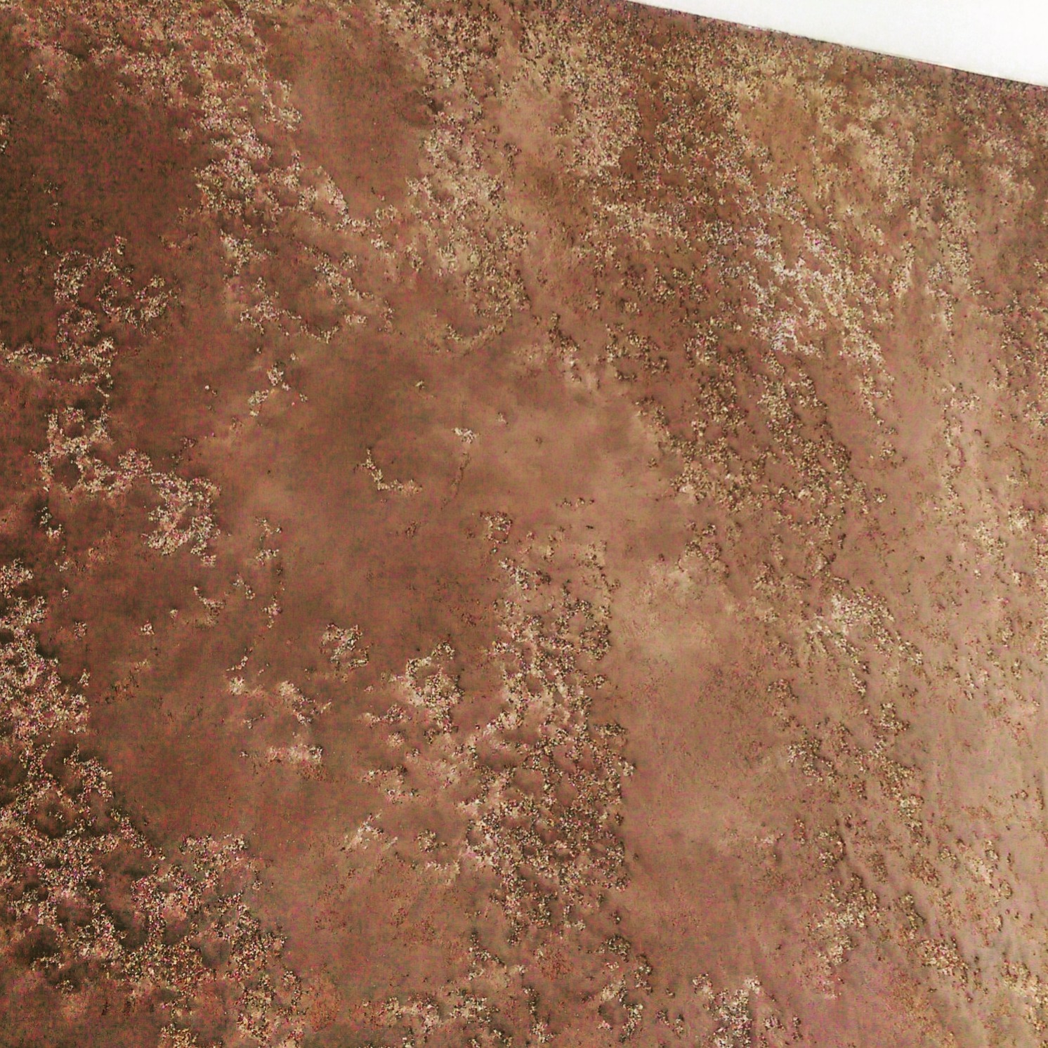 Brązowa ściana z dekoracyjną, nierównomierną fakturą przypominającą rdzę, widoczne drobne, jaśniejsze plamki i smugi.