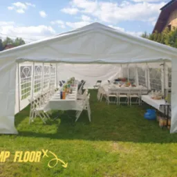 Biały namiot plenerowy z rozstawionymi stołami i krzesłami na trawniku, przygotowany do imprezy.