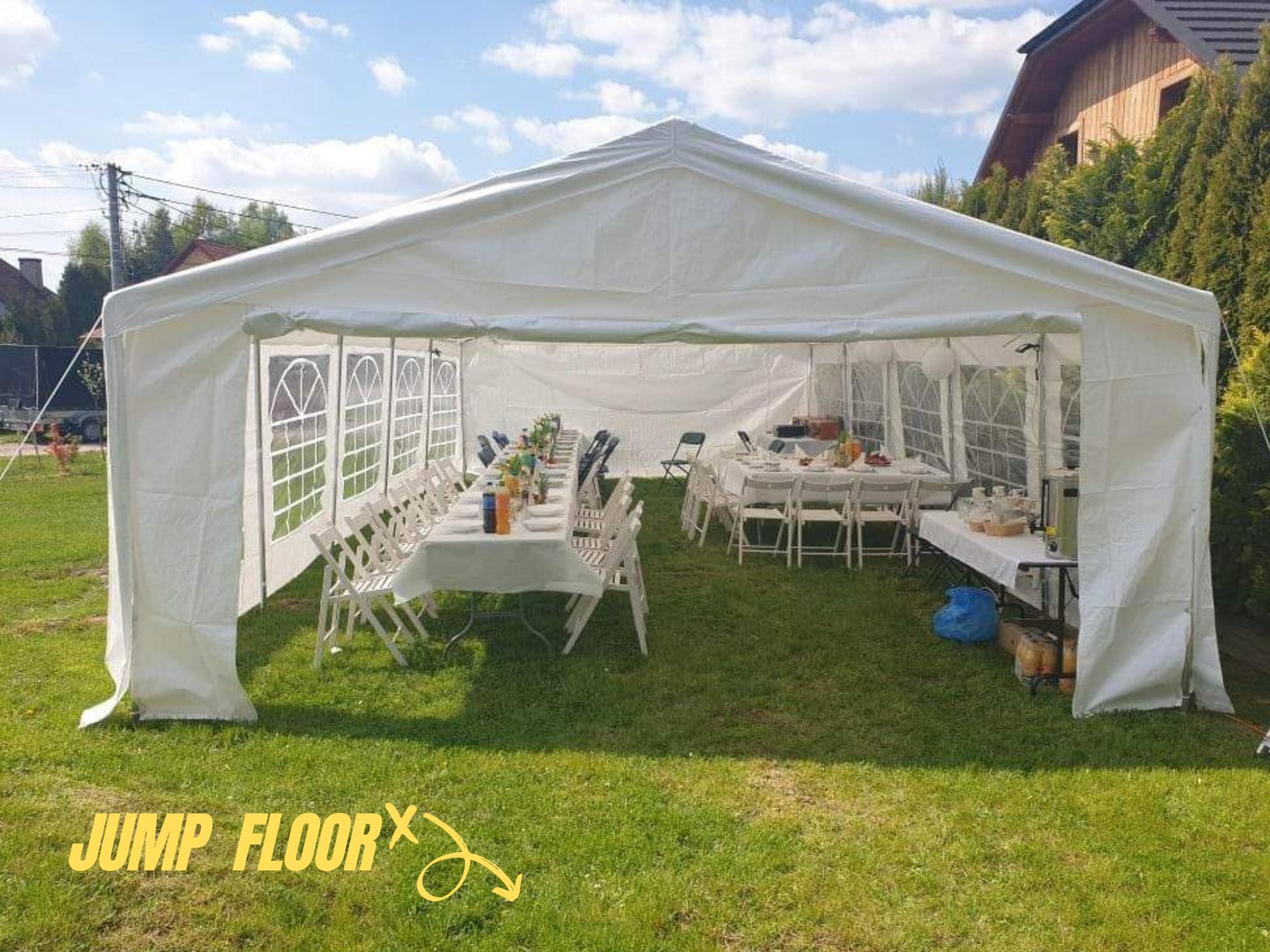 Biały namiot plenerowy z rozstawionymi stołami i krzesłami na trawniku, przygotowany do imprezy.