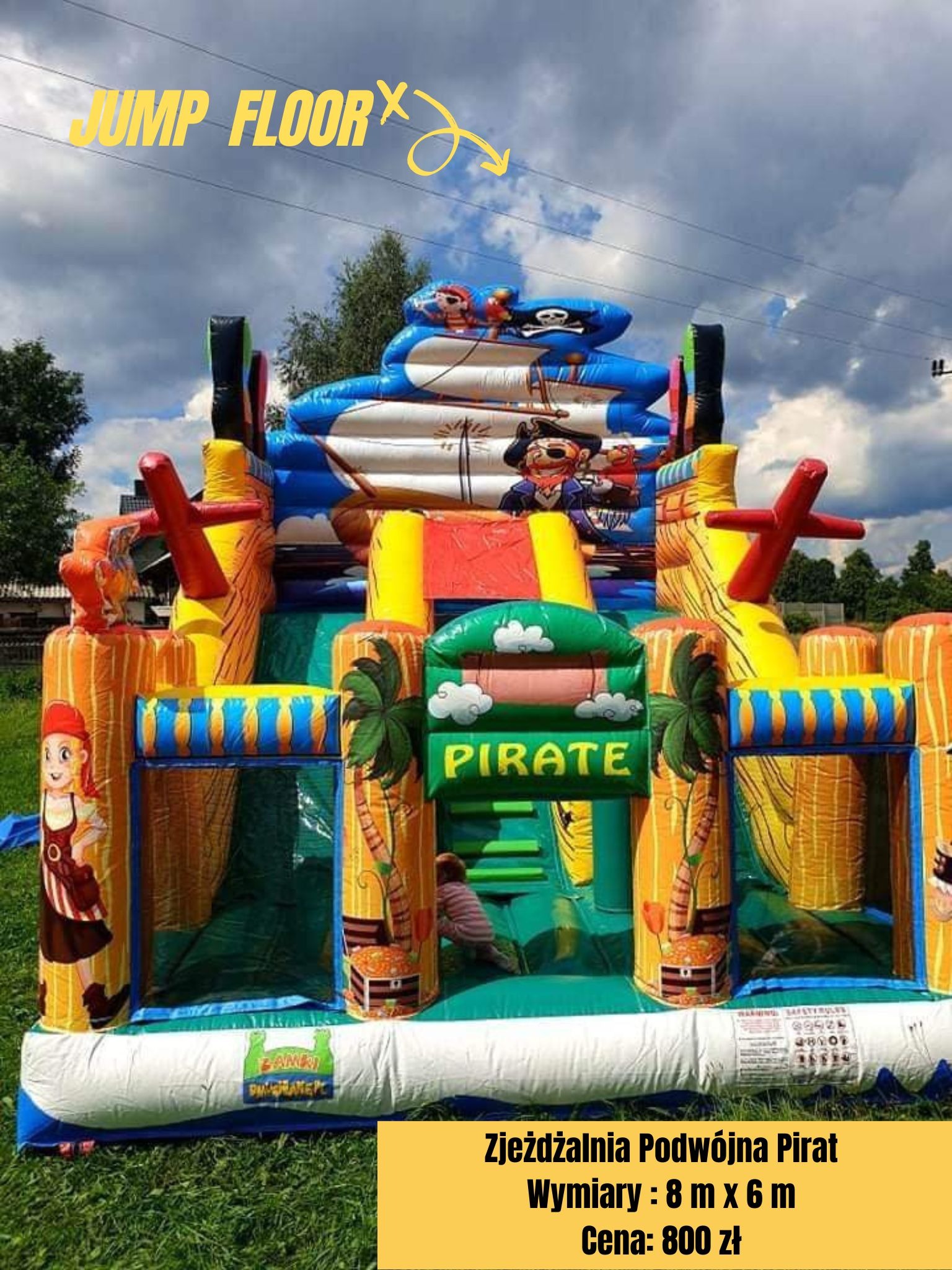 Kolorowa, dmuchana zjeżdżalnia w stylu pirackim z motywami piratów, palm i skrzyń ze skarbami, ustawiona na trawie w plenerze.