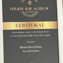 Oprawiony w białą ramkę certyfikat PZU dla Beaty Górczyńskiej, potwierdzający członkostwo w elitarnym klubie agentów 2022, z podpisem Piotra Półrolnika, Dyrektora Biura Sprzedaży Własnej.