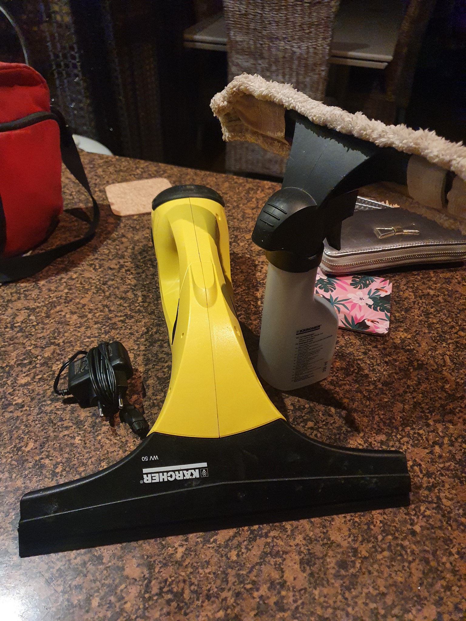 Elektryczna myjka do okien Kärcher WV 50, butelka ze spryskiwaczem i inne akcesoria na blacie w Sławicy.