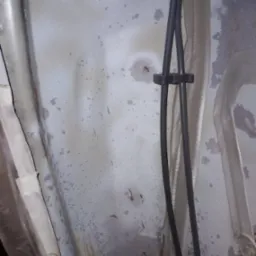 Spód elementu karoserii pojazdu po piaskowaniu, przygotowany do dalszej obróbki. Widoczne ślady po procesie, resztki taśmy maskującej i przewody.