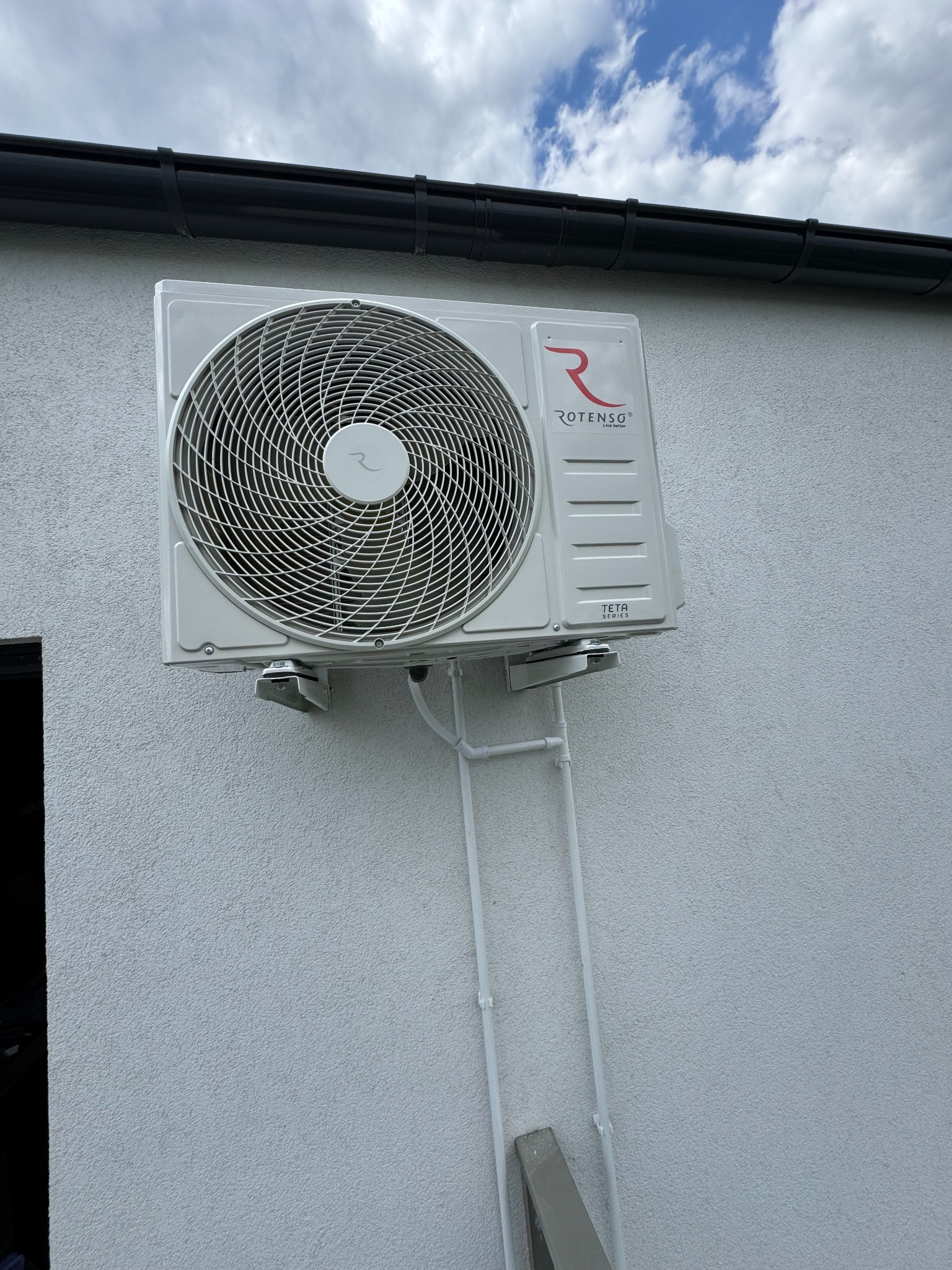 Zamontowana jednostka zewnętrzna klimatyzacji Rotenso Teta Series na elewacji budynku w Inowrocławiu, z widocznymi rurami odprowadzającymi.
