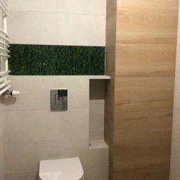 Marcin Pawluczuk Remonty - Nowoczesna łazienka z toaletą, białe płytki, panel z mchu dekoracyjnego i drewnopodobna okładzina ścienna.