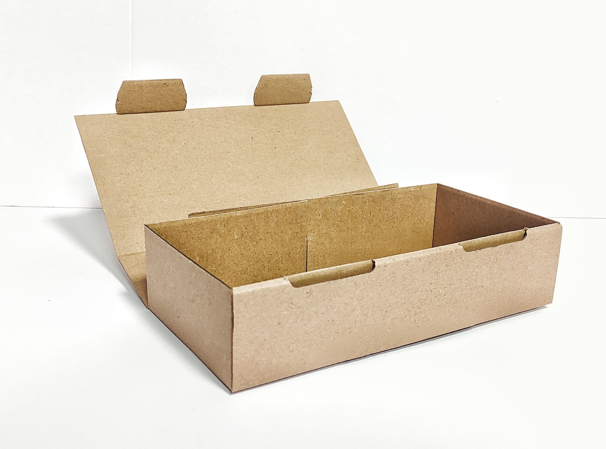 Otwarta, pusta, tekturowa skrzynka z klapami, gotowa do złożenia, na białym tle.