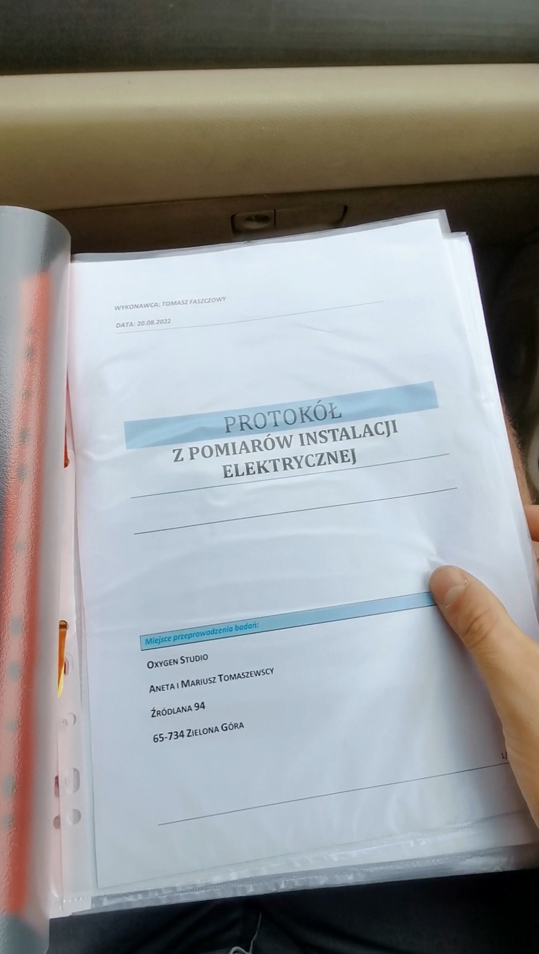 Otwarty segregator prezentuje protokół z pomiarów instalacji elektrycznej, wykonany przez Tomasza Faszczowego, z datą 20.08.2022, dla Oxygen Studio w Zielonej Górze.