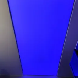 Trapezoidalny panel sufitowy z intensywnym niebieskim podświetleniem LED, widoczny z dołu, z elementami konstrukcyjnymi sufitu w odcieniach szarości.