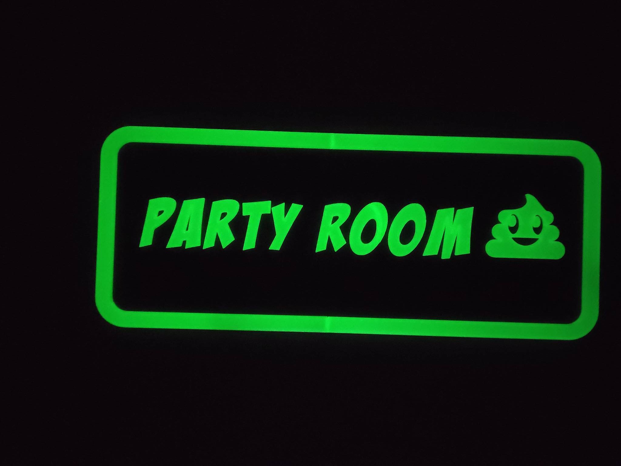 Świecący na zielono napis 'PARTY ROOM' z emotikonem kupy w prostokątnej ramce na czarnym tle.