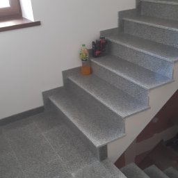 Wojciech Gąsienica - Schody i podłoga wyłożone płytkami imitującymi kamień, z butelką soku i laserowym niwelatorem na stopniu.