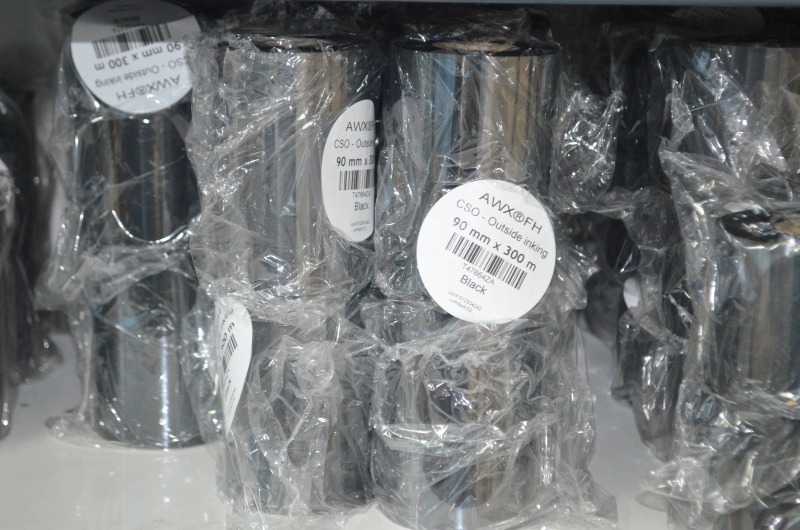 Rolki czarnej taśmy barwiącej AWX FH CSO o wymiarach 90 mm x 300 m, zapakowane w folię.