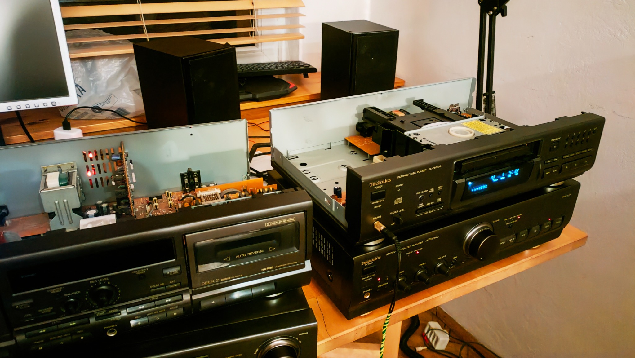 Rozłożony, czarny zestaw stereo Technics z otwartymi obudowami magnetofonu i odtwarzacza CD, ukazujący wewnętrzne komponenty elektroniki.