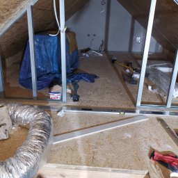 Iberhome - Montaż stelaża z profili metalowych na poddaszu, widoczne narzędzia, materiały izolacyjne i wentylacja. Prace wykończeniowe w trakcie realizacji.