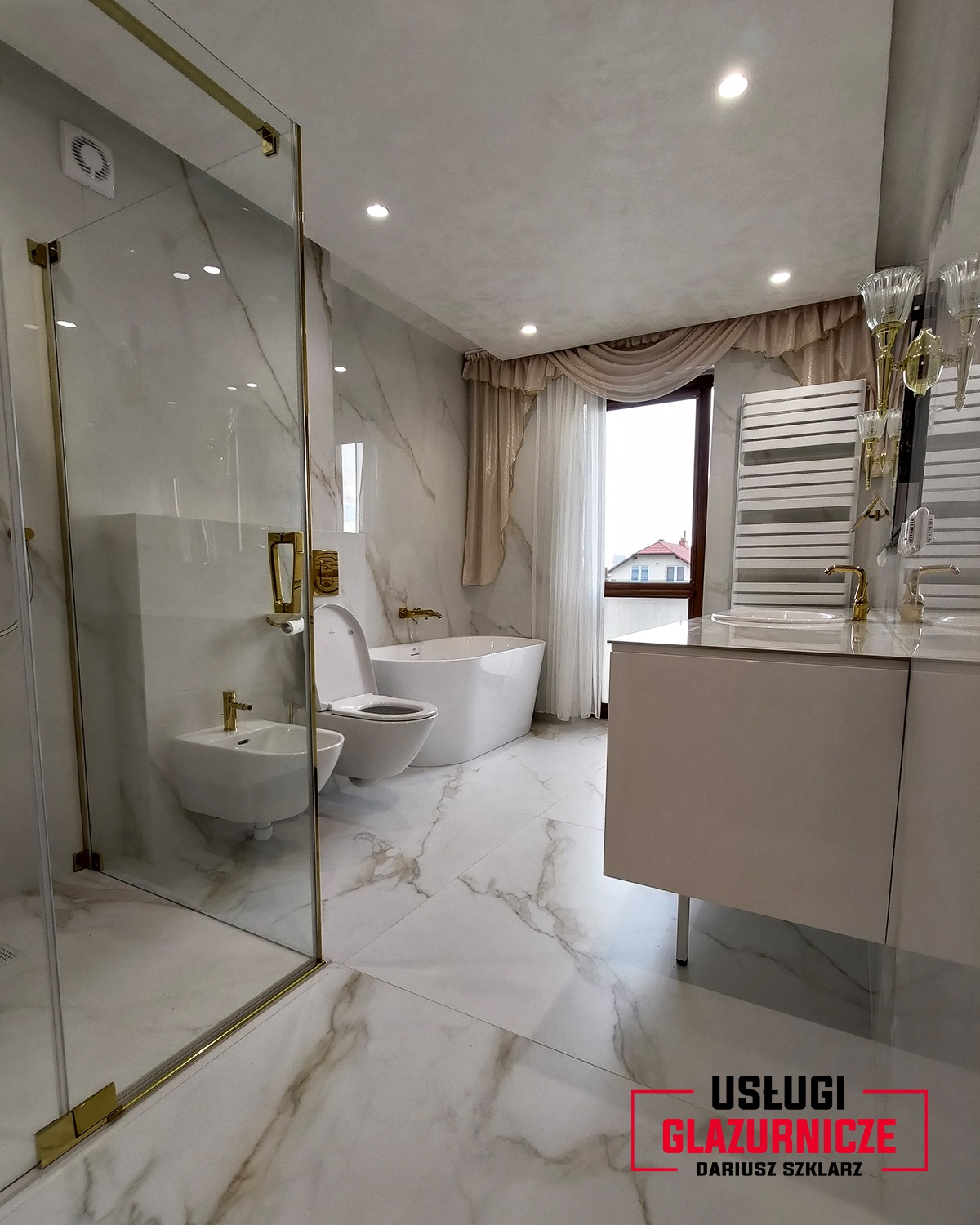 Elegancka łazienka z płytkami imitującymi marmur na ścianach i podłodze, kabina prysznicowa ze złotymi okuciami, wolnostojąca wanna i bidet, okno z dekoracyjnymi zasłonami w tle.