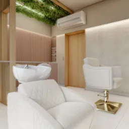 Wnętrze salonu fryzjerskiego z dwoma białymi fotelami z pikowaną tapicerką, myjnią fryzjerską i drewnianymi elementami dekoracyjnymi z roślinami na suficie.